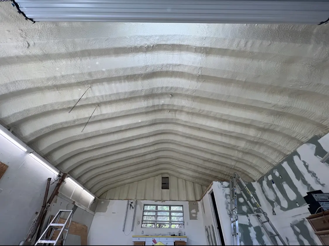 Spray polyurethane foam applied to the underside of a metal roof deck in Ash